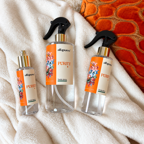Tri veľkosti Purity Textile Spray spolu na deke.